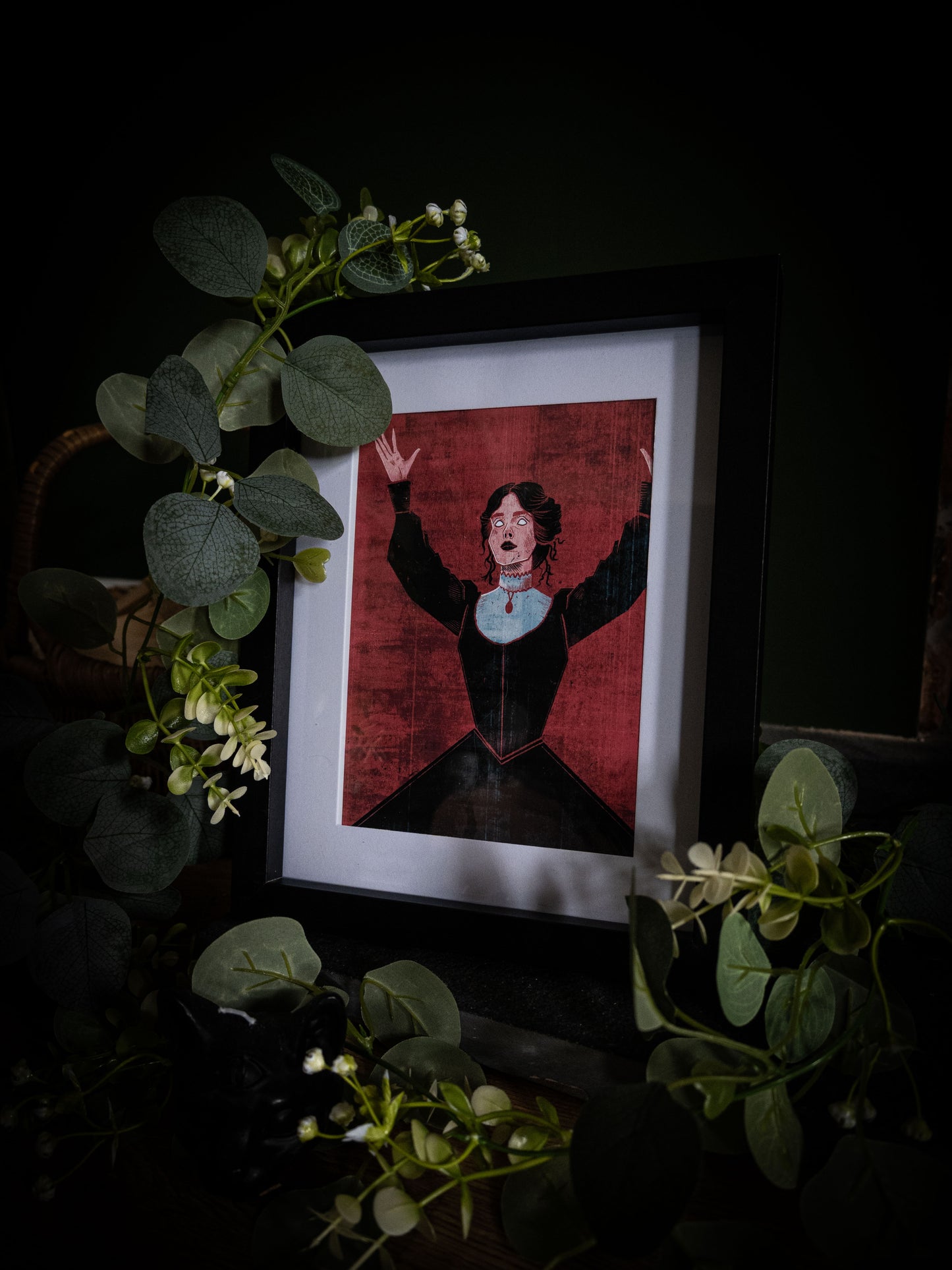 Full view of Mina Dracula art print in black frame, deep crimson and dark gothic styling with trailing eucalyptus and white blooms