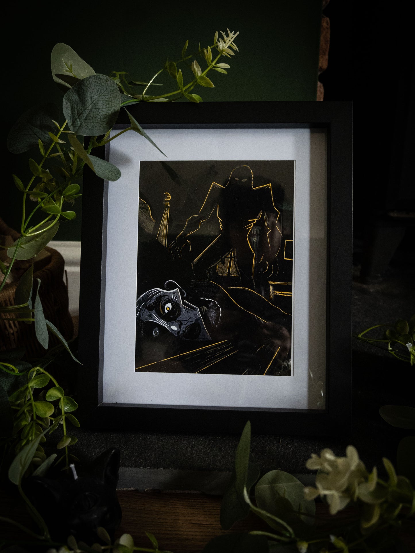 Framed gothic art print of Elizabeth's murder on her wedding night, looming creature in gold linework over prone figure, from Sophie Atkinson's Frankenstein Illustrated series