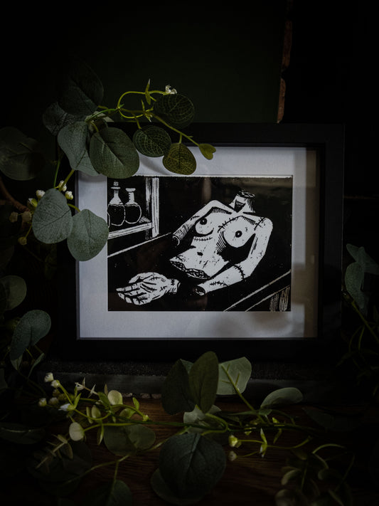 The Workshop art print angled view — creature laid out in Victor's laboratory, bold black and white gothic illustration