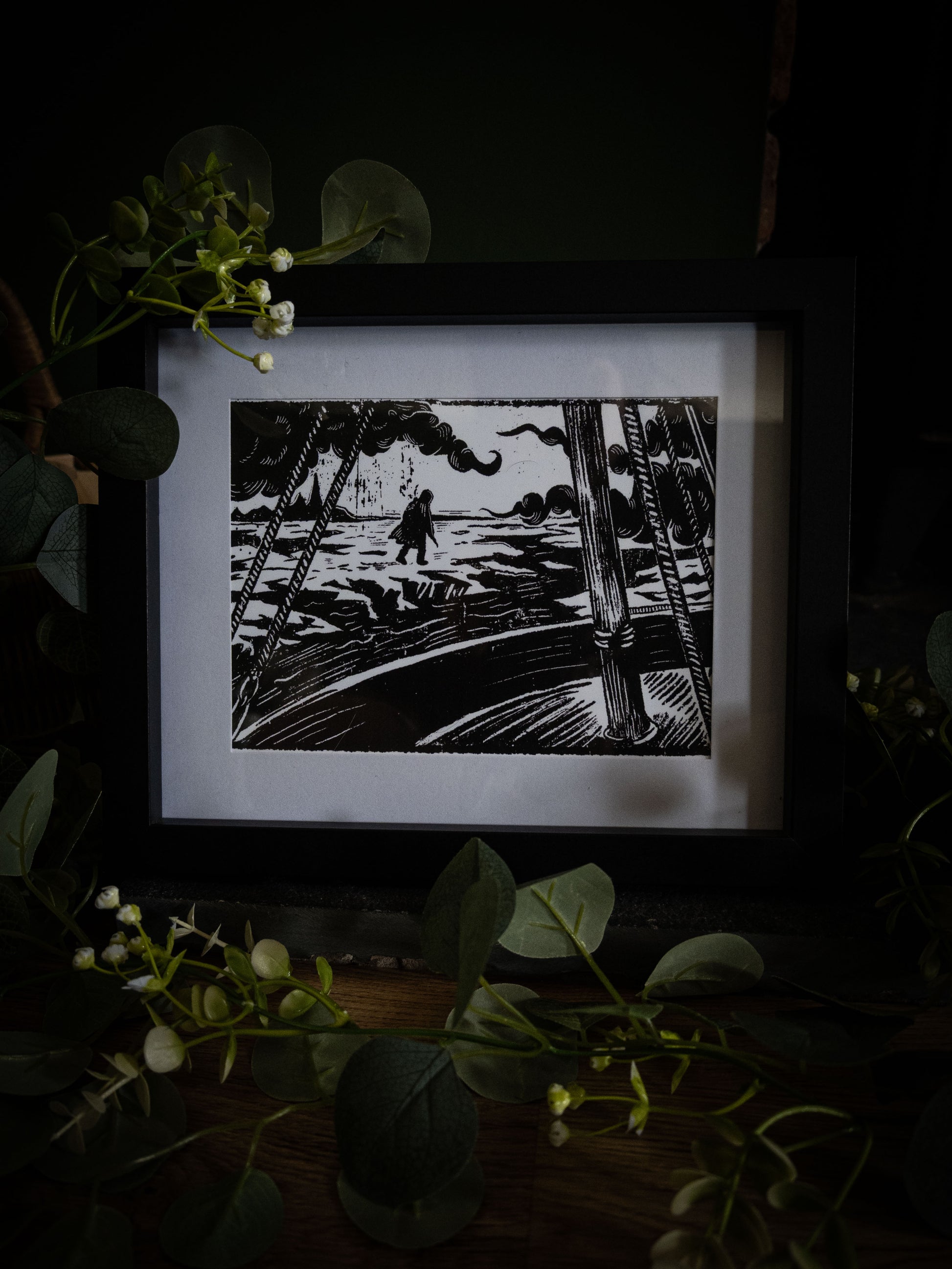 The Figure on the Ice giclée print displayed with winter foliage — Frankenstein Arctic scene viewed through ship rigging, gothic artwork by Sophie Atkinson