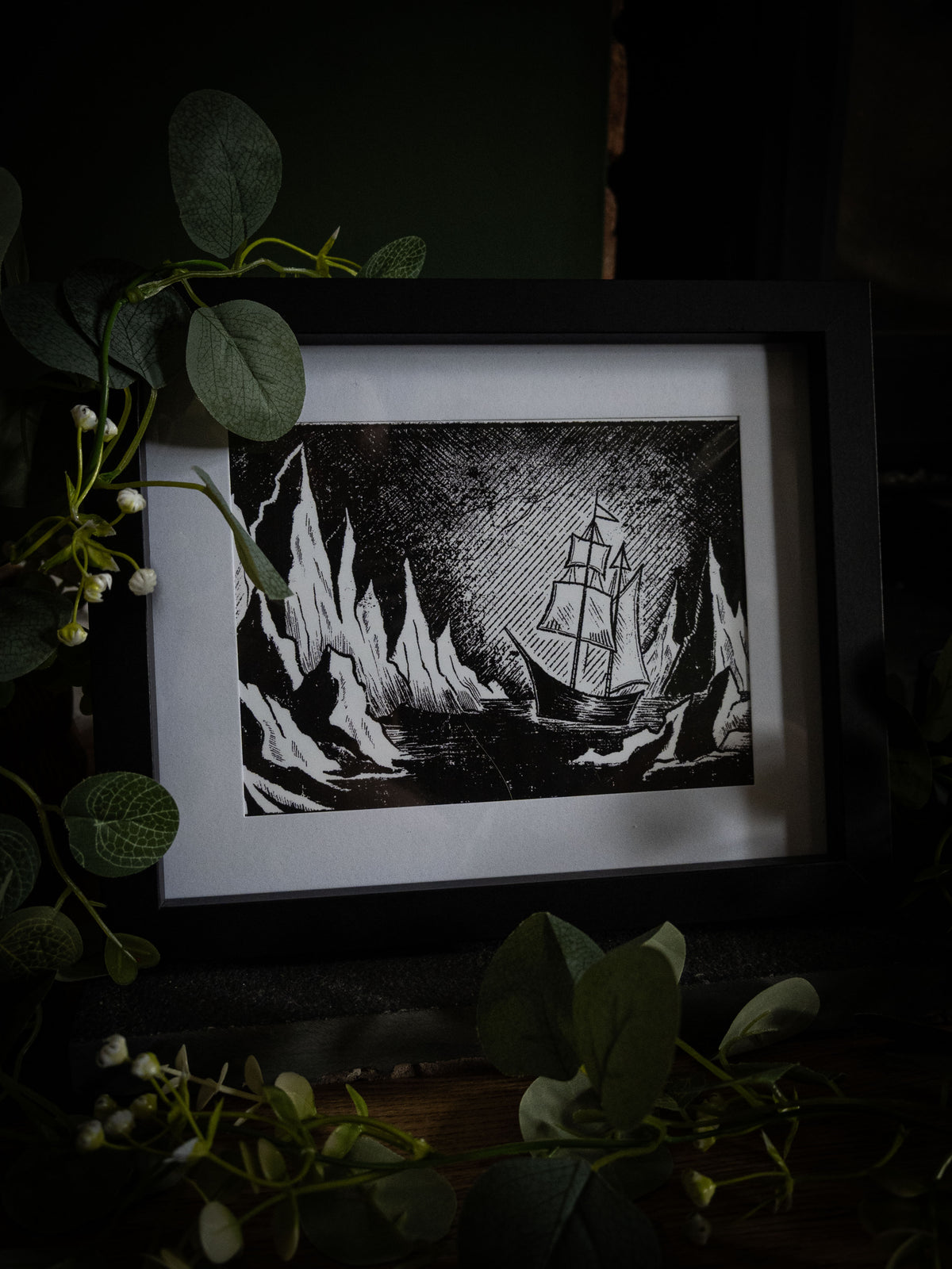 The Arctic giclée print displayed with winter foliage — Frankenstein Arctic expedition ship between icebergs, gothic artwork by Sophie Atkinson
