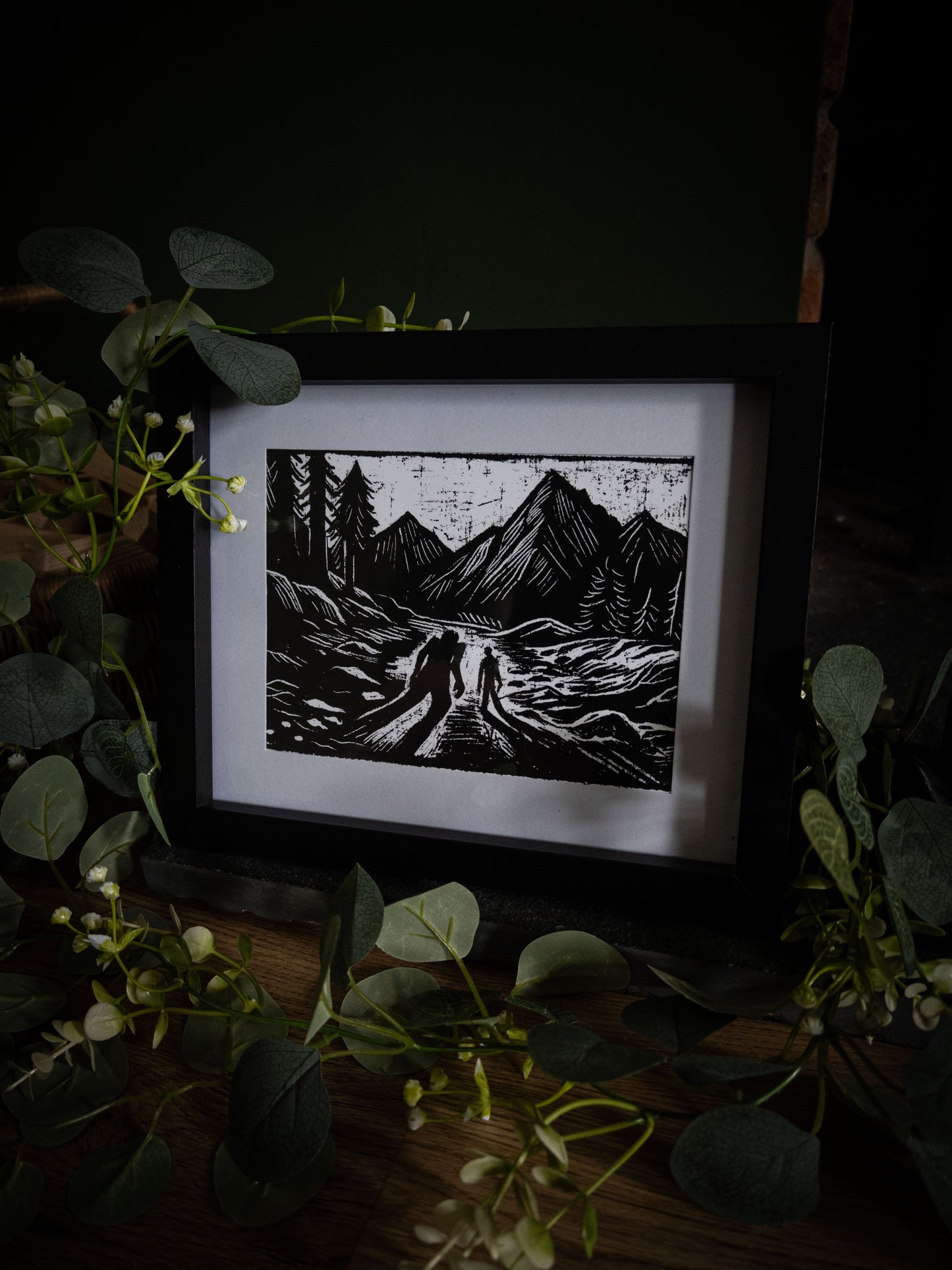 The Alpine Pass art print with wicker basket and foliage — two silhouettes on Alpine track, Frankenstein illustrated vignette by Sophie Atkinson