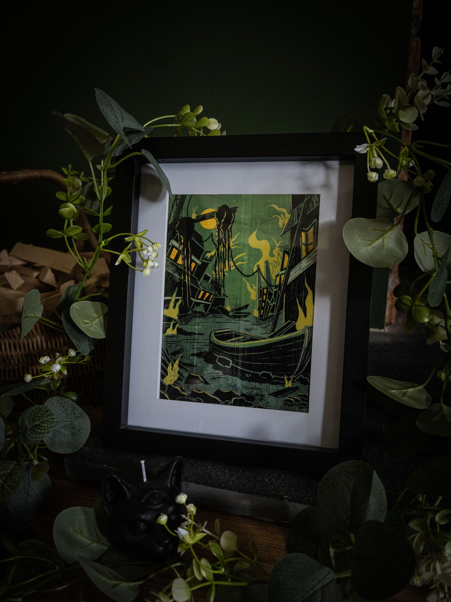 Something Wrong in Innsmouth art print in black frame – angled shot showing rotting harbour, lone boat and cosmic horror elements by Sophie Atkinson