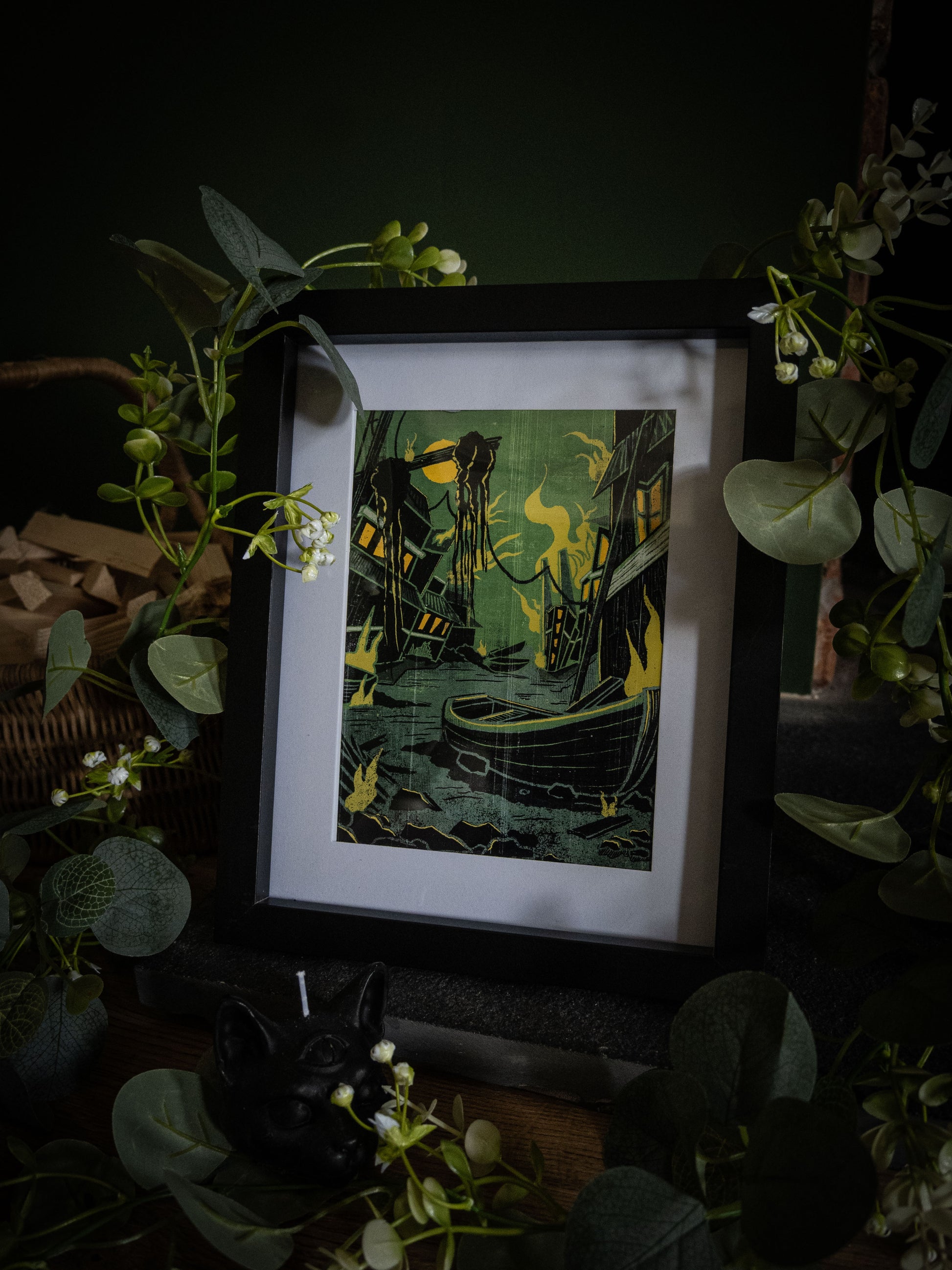 Something Wrong in Innsmouth art print in black frame – angled shot showing rotting harbour, lone boat and cosmic horror elements by Sophie Atkinson