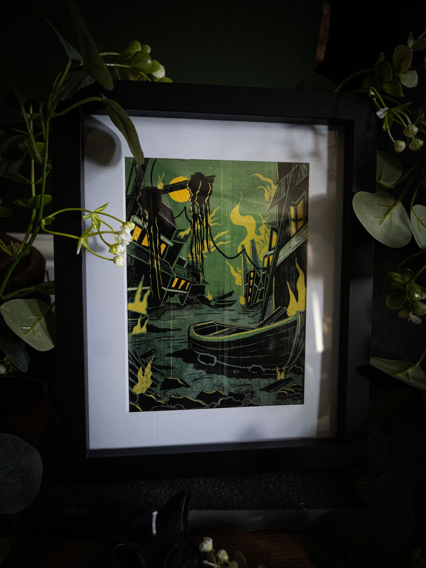 Framed Innsmouth Lovecraft print – deep green harbour scene with tentacled shadow and yellow flames, dark moody product photography with white flowers
