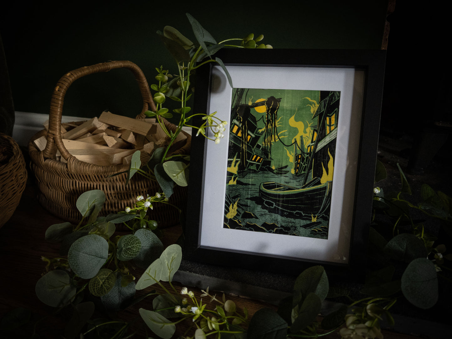 Something Wrong in Innsmouth art print in black frame – side angle showing deep green and black Lovecraft harbour scene with yellow flame accents