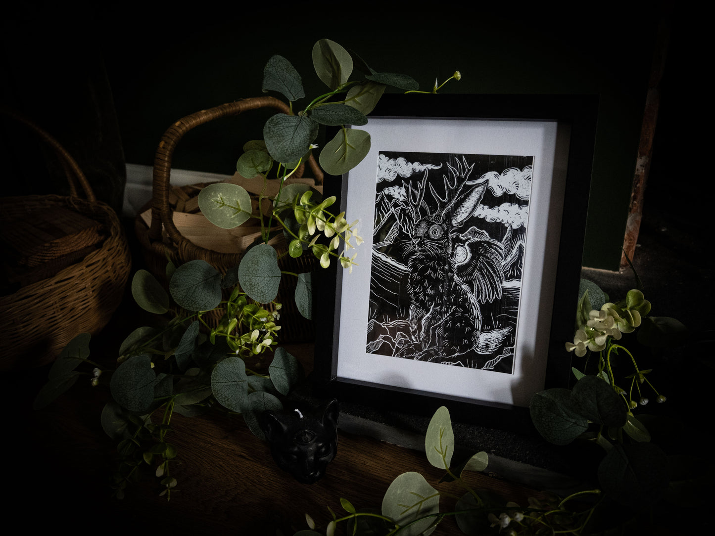 Framed Jackalope gothic illustration print by Sophie Atkinson, moody dark background with eucalyptus leaves and wicker basket