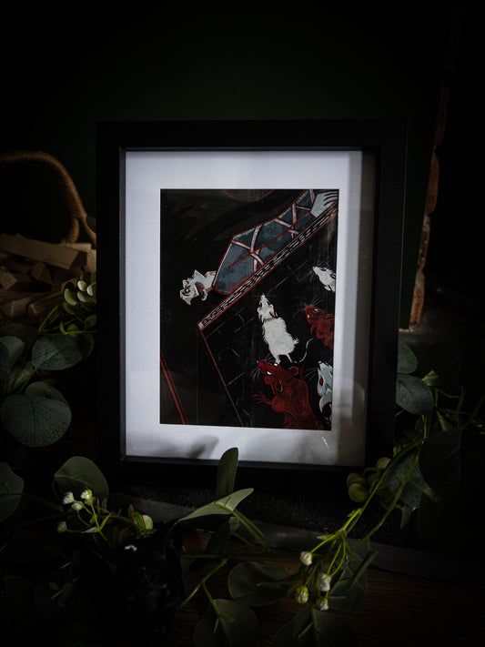 Full view of The Pit and the Pendulum gothic art print in black frame, deep black and crimson illustration with trailing eucalyptus and white blooms