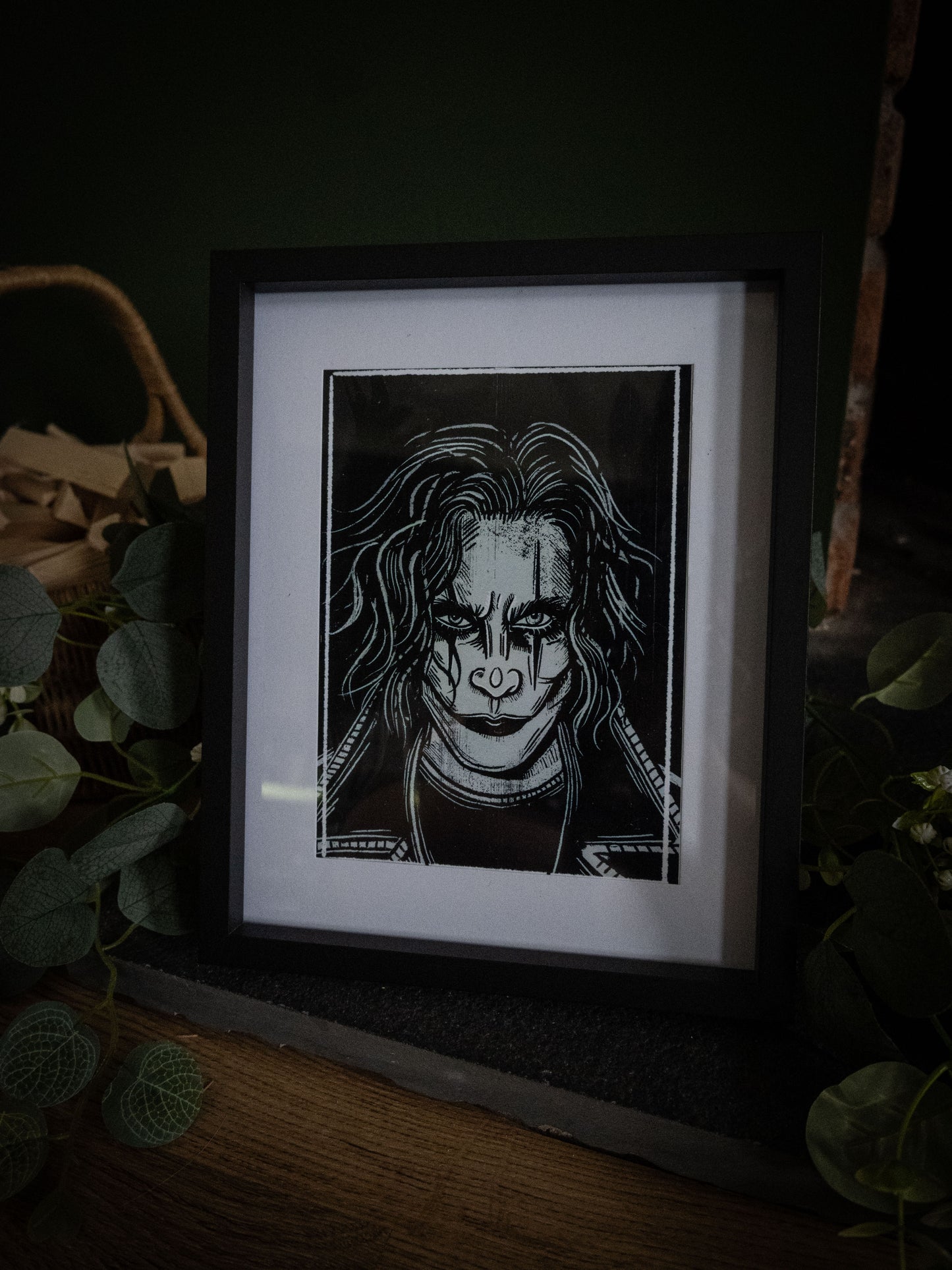 The Crow horror art print in black frame styled with white flowers