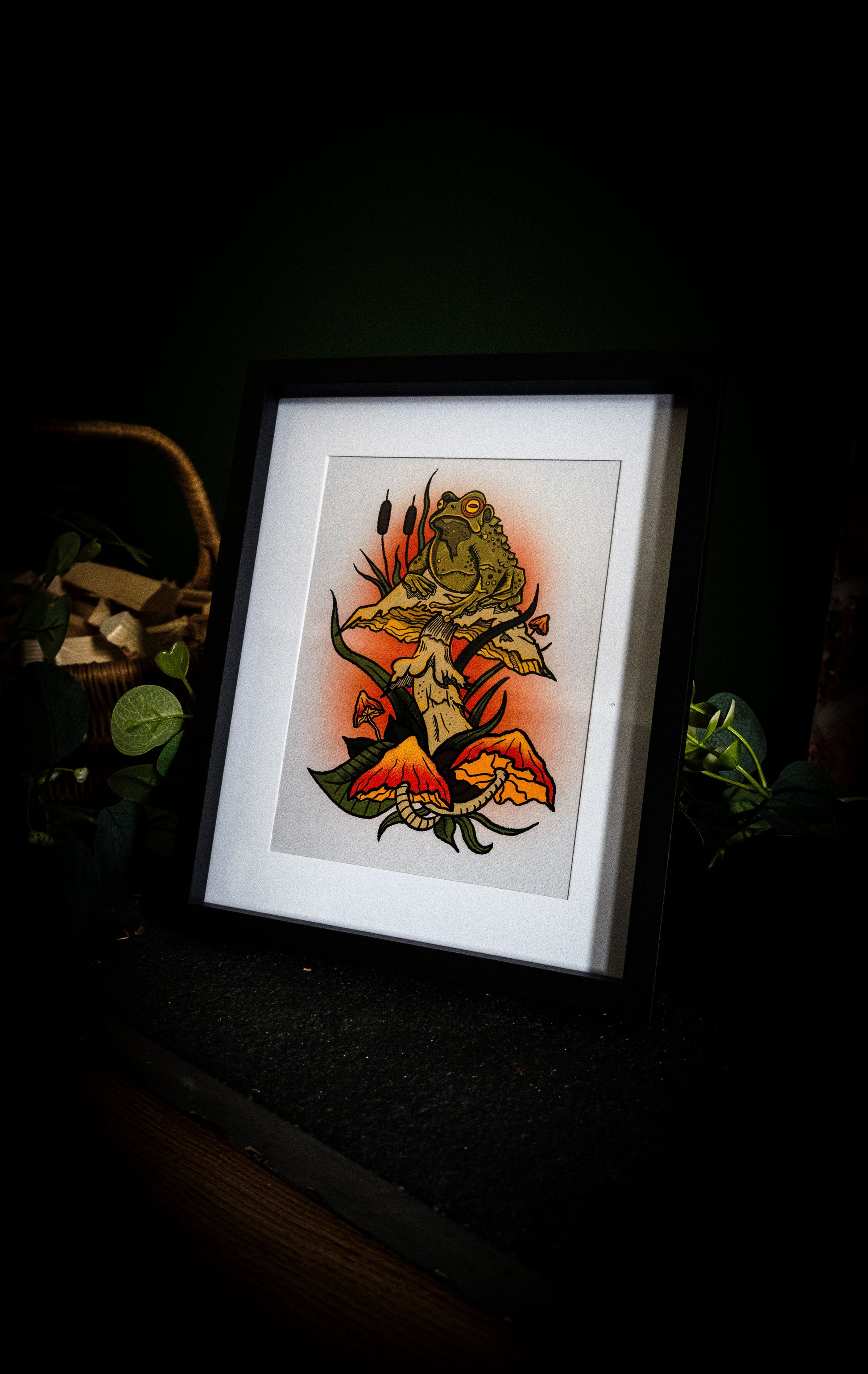 Witch's Familiar toad and mushroom giclée print in black frame, close up showing rich colour detail
