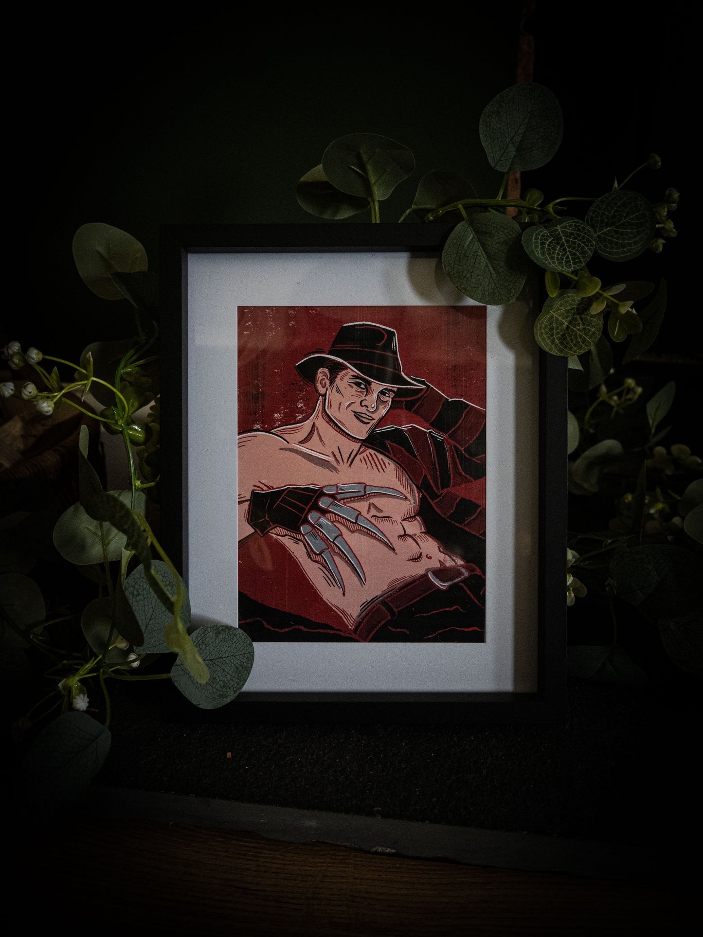 Sexy Freddy Krueger pinup art print in white frame — gothic horror wall art by Sophie Atkinson, deep red woodblock illustration style