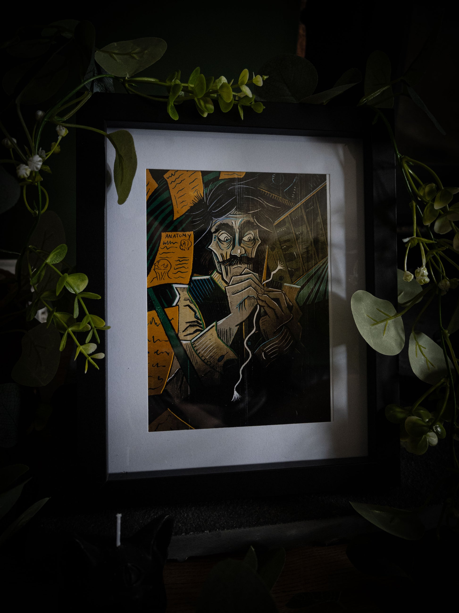 Victor giclée print displayed with greenery — wild-eyed Victor Frankenstein at work with needle and thread, colour gothic artwork by Sophie Atkinson