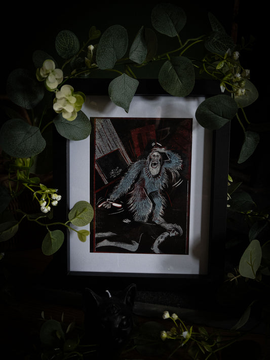 Close-up of Murders in the Rue Morgue illustration print in black frame, bold woodblock-style artwork of rampaging creature in deep teal and black with crimson accents, styled with botanical foliage